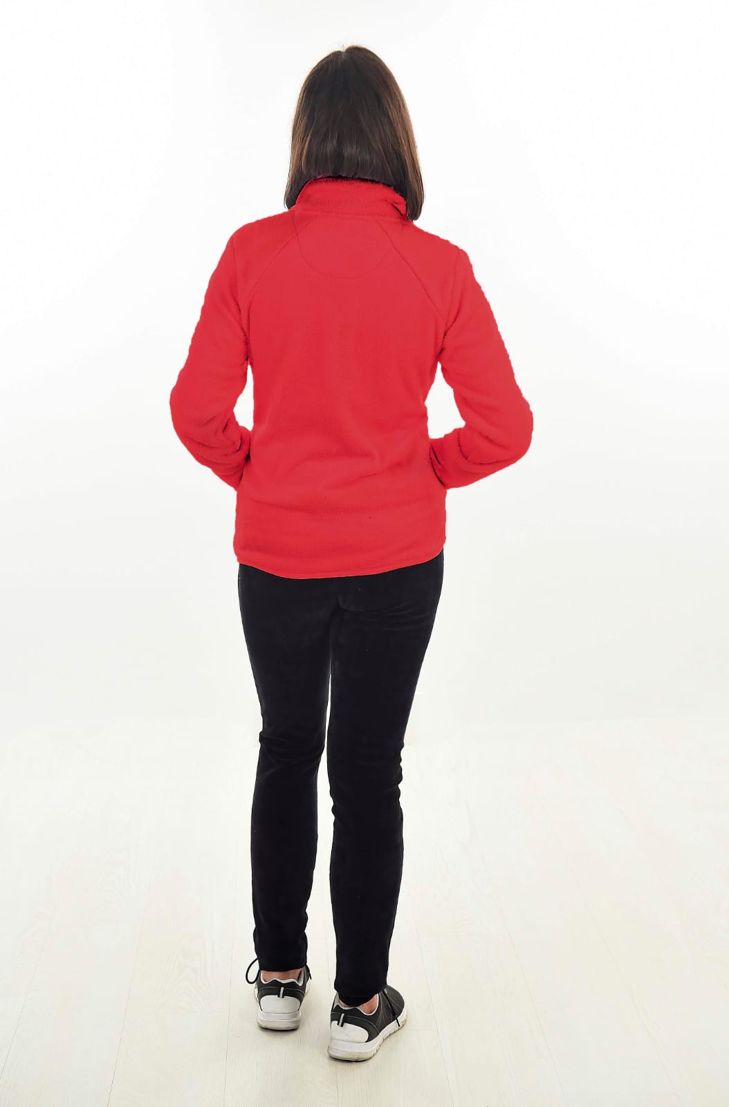 MUJER EN FONDO BLANCO CON UN PANTALON NEGRO Y UNA CHAQUETA ROJA DE TEJIDO PELUCHE