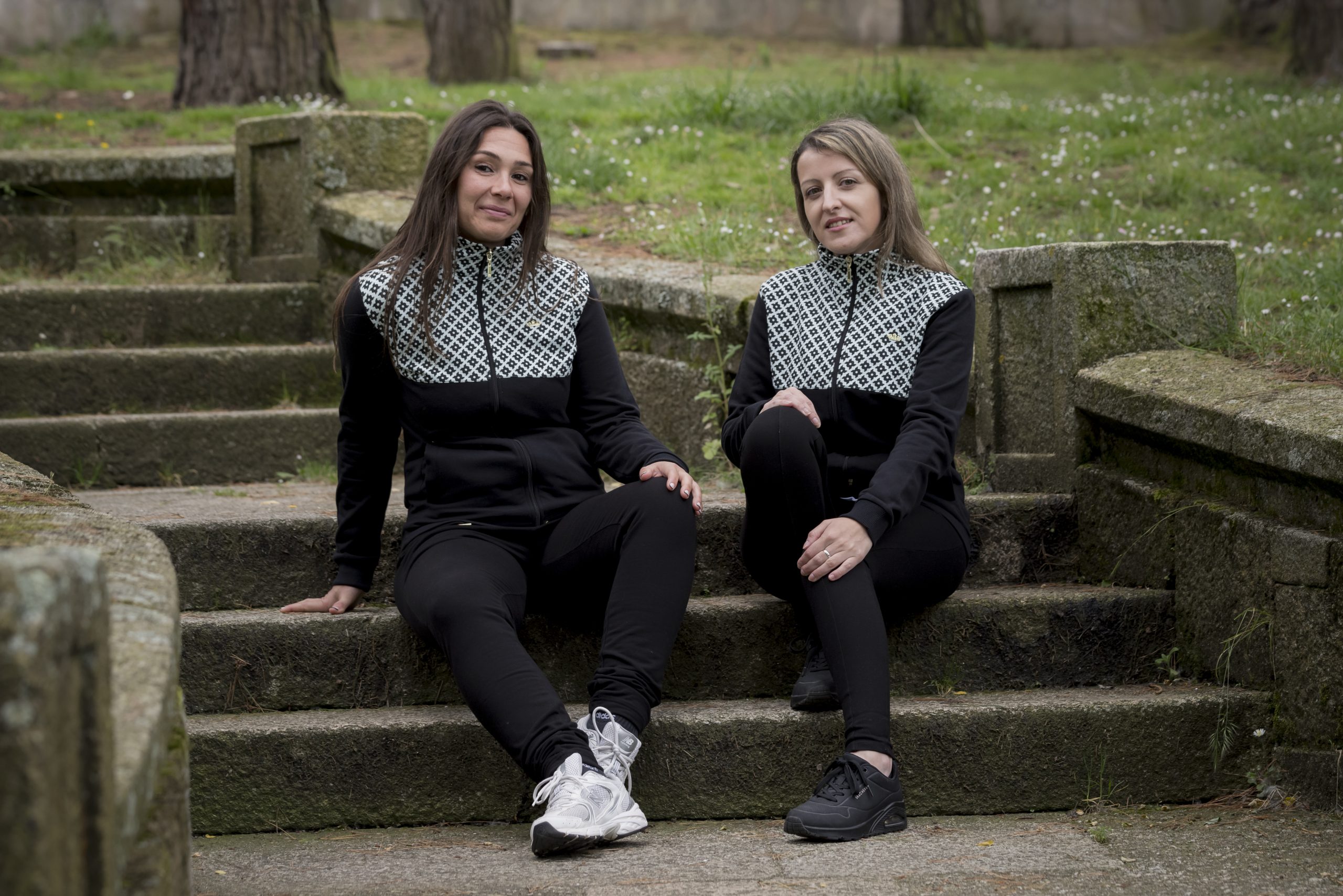 DOS MUJERES SENTADAS EN UNOS ESCALONES DE UN PARQUE