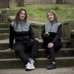 DOS MUJERES SENTADAS EN UNOS ESCALONES DE UN PARQUE