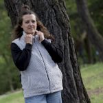 Mujer con chaqueta de pelo gris y negra en bosque